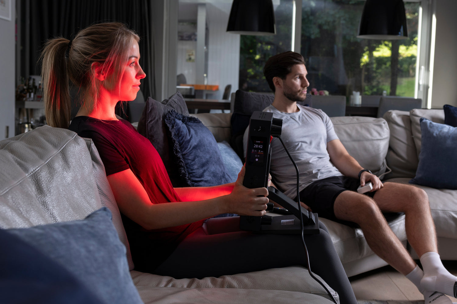 woman sitting on couch and getting red light therapy
