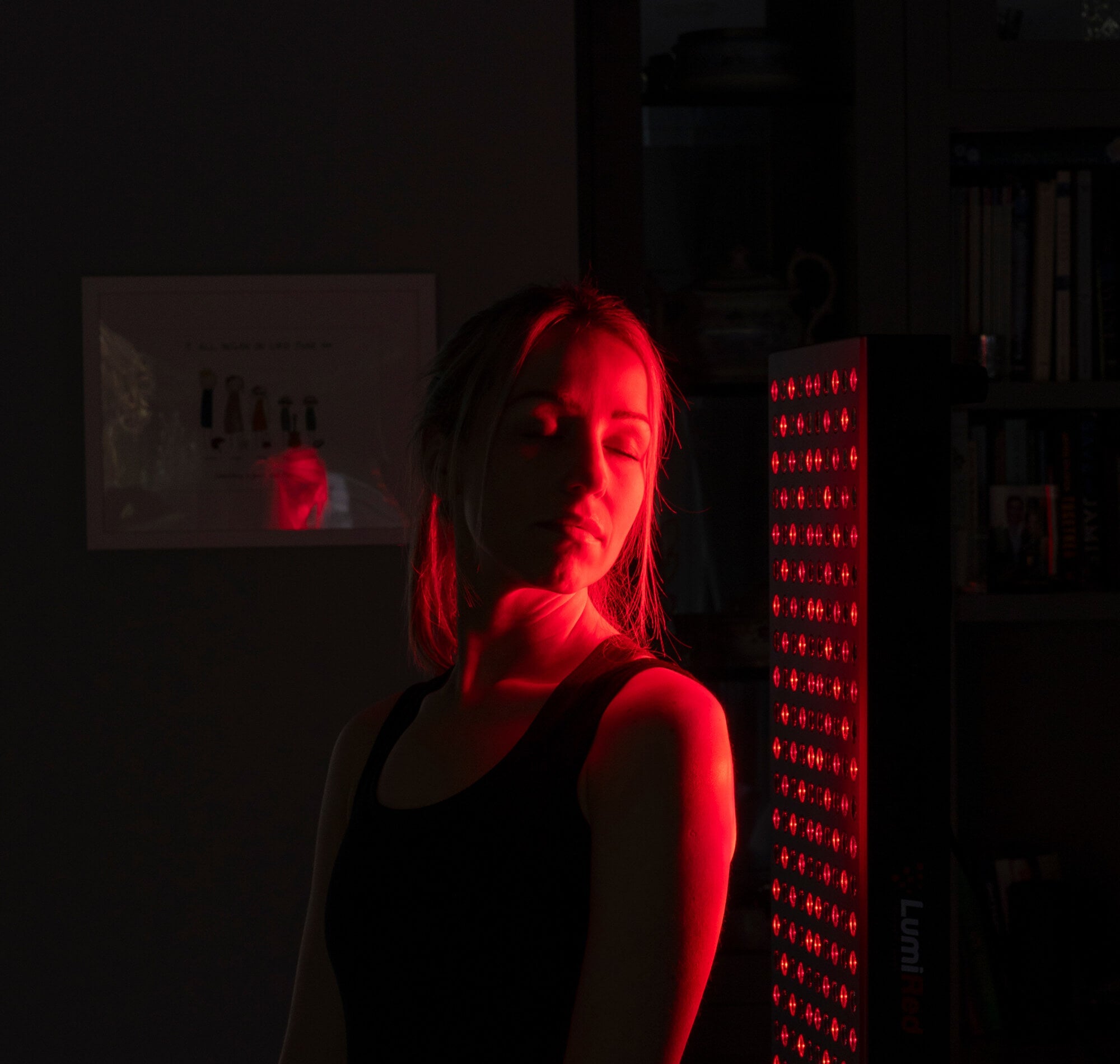 Woman standing in front of red light panel