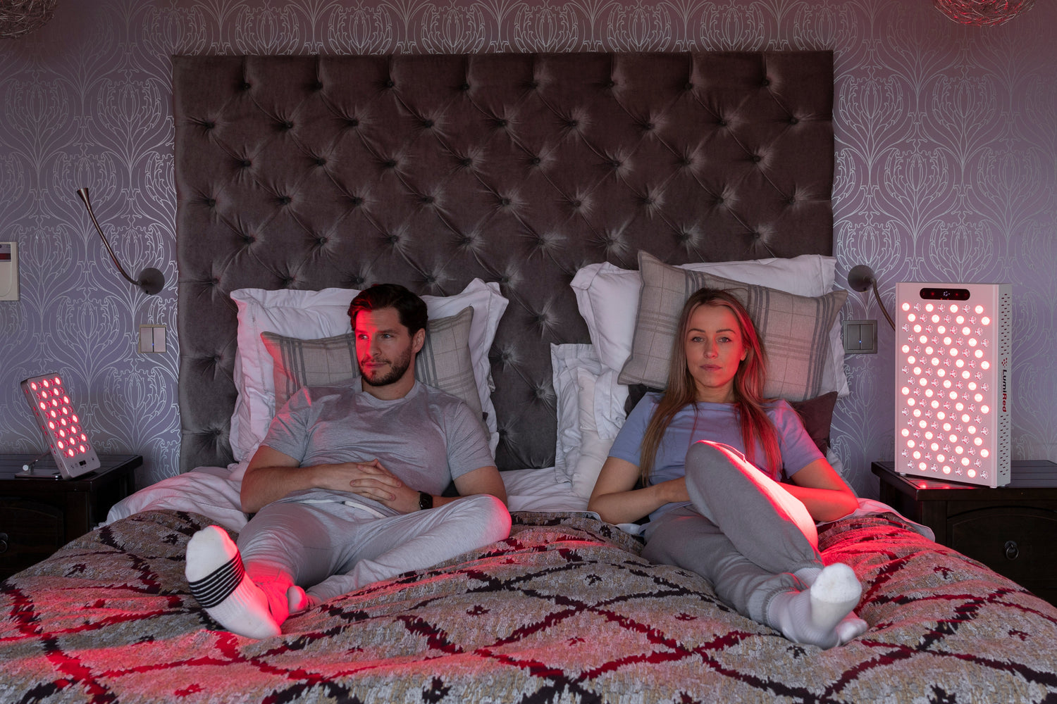 woman and man getting red light therapy on their bed