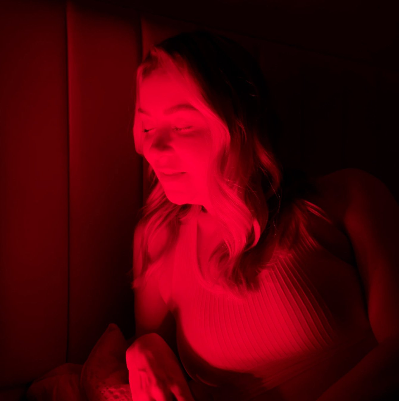 female in front of red light lamp for hair growth