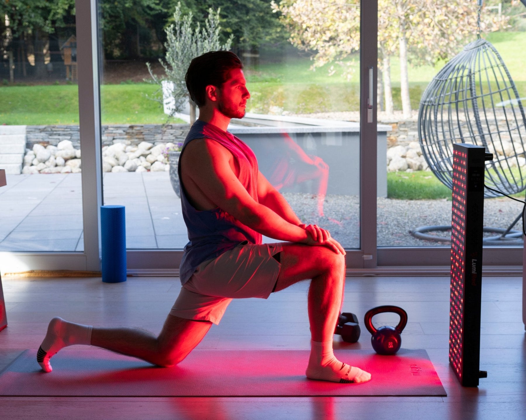 A man exercising in front of LumiRed red light therapy panel