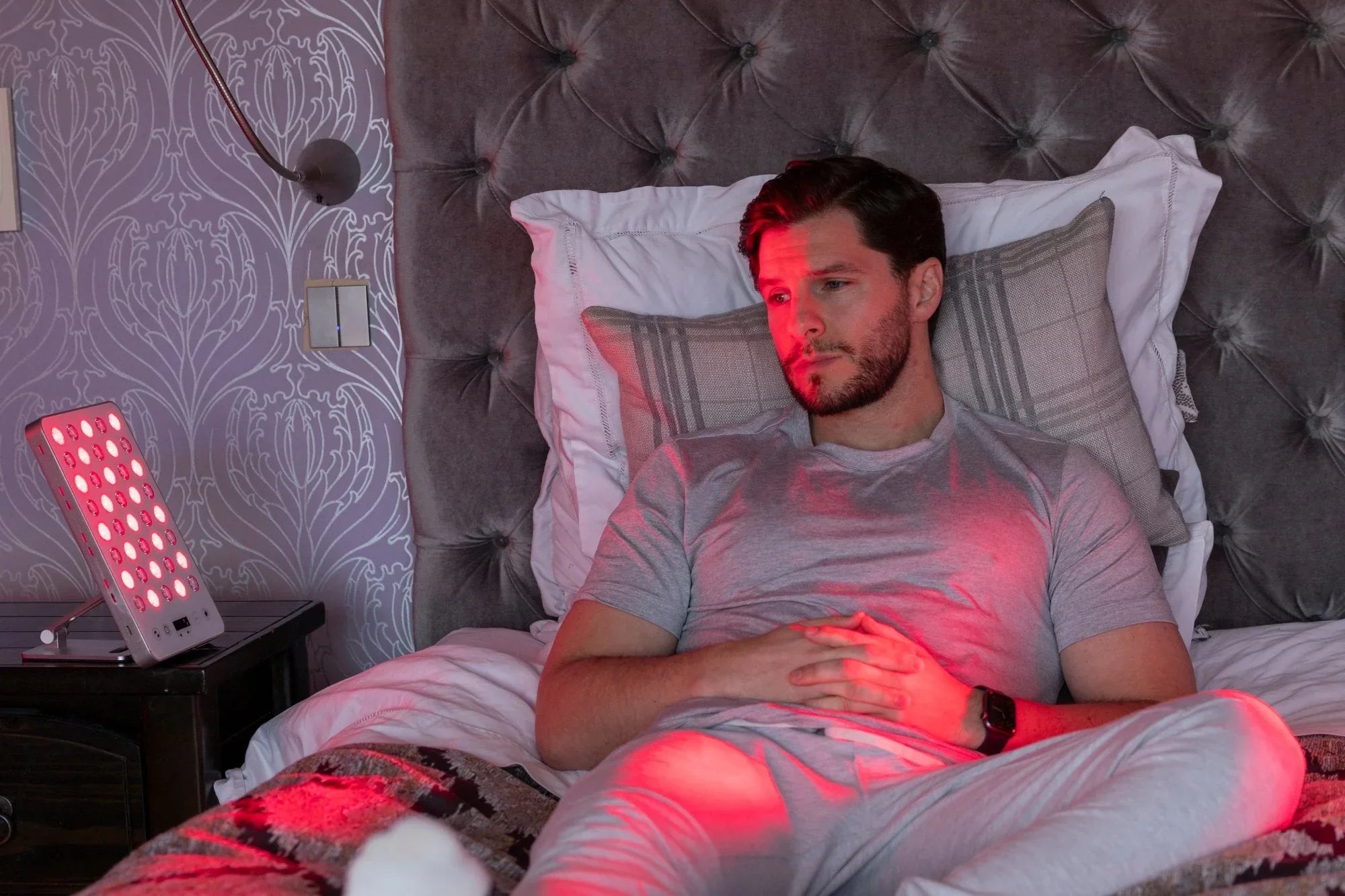 A man lying in front of LumiRed device for better sleep quality