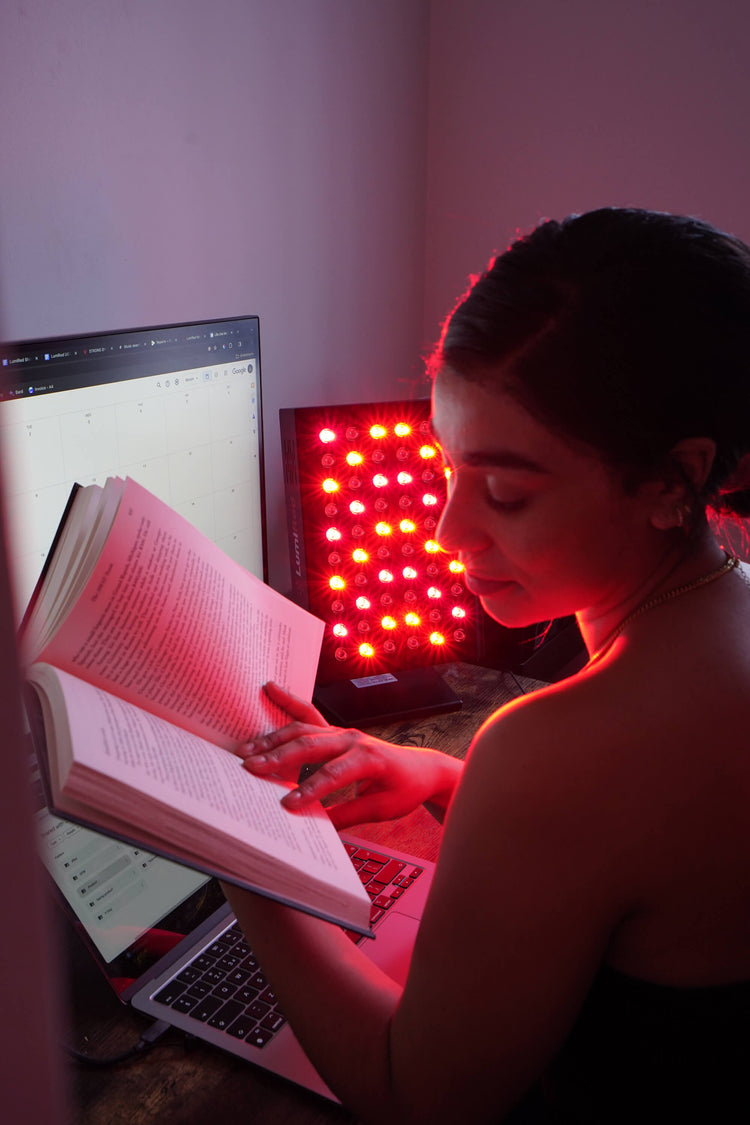A girl reading her book in from of LumiRed Light Therapy Panel
